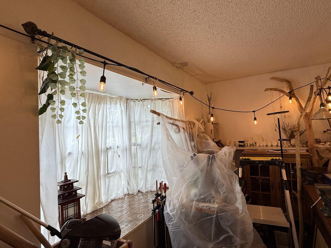 Orlando room with the ceiling stained by a roof leak and the contents covered in plastic before remediation