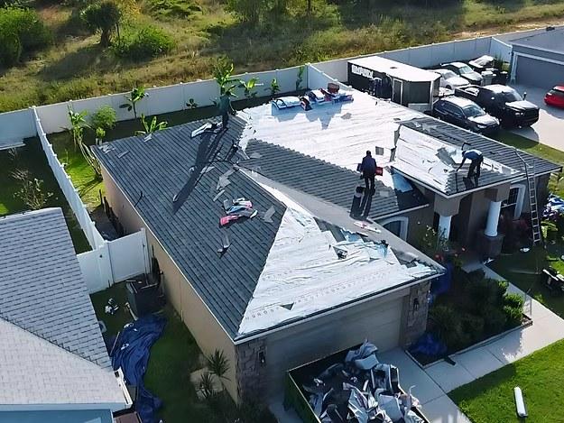 Aerial view of the ELR crew working on the roof, old shingle stripped and synthetic underlayment exposed mid-job